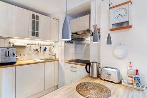 a kitchen with white cabinets and a wooden counter top at Casa Stadtblick in Gengenbach