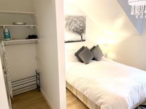 2 imágenes de un dormitorio con una cama blanca en London Studio Self Contained, Newly Furbished, en Londres