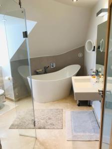 a bathroom with a bath tub and a sink at College View in Cheltenham