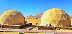 two domed tents in the desert with mountains in the background at Darien Luxury Camp in Wadi Rum
