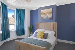 吉林漢姆的住宿－Reve Bleu，一间拥有蓝色墙壁的卧室和一张带蓝色窗帘的床