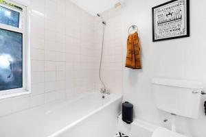 a white bathroom with a tub and a window at Reve Bleu in Gillingham