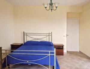 Un dormitorio con una cama con sábanas azules y una lámpara de araña. en La casa del Pastore, en Rutino