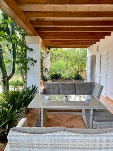 eine Terrasse mit einem Tisch und Korbstühlen in der Unterkunft Villa Can Toni Miquelí in Santa Gertrudis