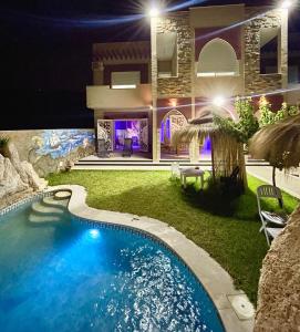 una casa con piscina por la noche en Master Suite in Bellavista Andalucia with Pool and Beach en Al Matlīn