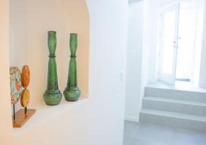 three green vases sitting on a shelf next to stairs at Casa do Pátio- Parking included in Évora