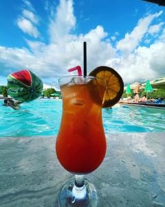 a drink sitting on a table next to a swimming pool at SUN GARDEN AND POOL 