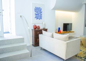 a living room with a white couch and stairs at Casa do Pátio- Parking included in Évora