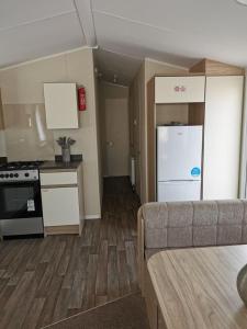 a kitchen with a white refrigerator and a stove at The mistral golden gate towyn in Kinmel Bay