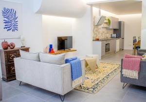 a living room with two chairs and a kitchen at Casa do Pátio- Parking included in Évora
