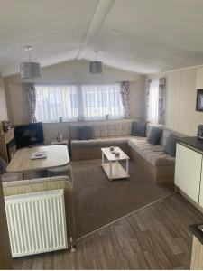 a living room with a couch and a table at The mistral golden gate towyn in Kinmel Bay