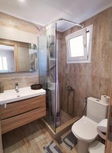 a bathroom with a shower and a toilet and a sink at Zante Ionian City House in Zakynthos Town