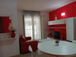 a living room with a white table and a red wall at Il Nido Rosso in Foligno