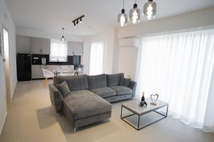ein Wohnzimmer mit einem Sofa und einem Tisch in der Unterkunft Ennea suites- Dark suite in Flámbouras