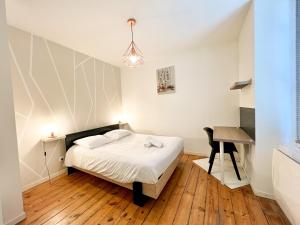 ペリグーにあるMAISON DE VILLE 10 personnes CLOS CHASSAING- WIFI -CENTRE VILLE -PROPERTY RENTAL NMのベッドと机のある小さな寝室