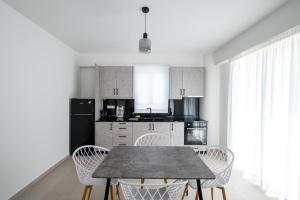 a kitchen with a table and chairs in a room at Ennea suites- Dark suite in Flámbouras