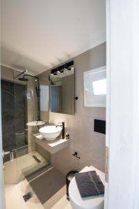ein Bad mit einem WC, einem Waschbecken und einer Dusche in der Unterkunft Ennea suites- Dark suite in Flámbouras