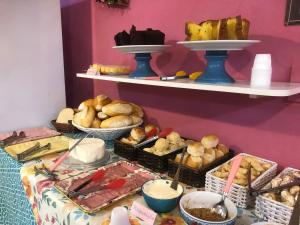 une table recouverte de beaucoup de différents types de pain dans l'établissement Pousada Chuá Chuá, à Conservatória