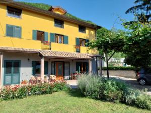 a yellow house with a car parked in front of it at Lanovella in Cava deʼ Tirreni