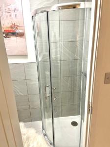 una ducha con puertas de cristal en una habitación en London Studio Self Contained, Newly Furbished en Londres