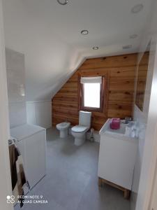 La salle de bains blanche est pourvue de toilettes et d'un lavabo. dans l'établissement Dom z bala w sercu Podlasia, à Białystok