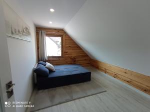 a bedroom with a blue bed in a attic at Dom z bala w sercu Podlasia in Białystok