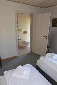 a room with two beds and a bathroom with a toilet at Šušvė in Plinkaigalis
