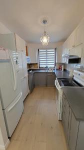 uma cozinha com electrodomésticos brancos e um frigorífico branco em Vacation House central location from anywhere in Montreal em Laval