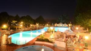 a large swimming pool at night with people sitting around it at Monteombraro Relax in Monte Ombraro