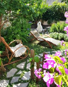 einen Garten mit Schaukel, Stühlen und Blumen in der Unterkunft Ca' do Dria in La Spezia