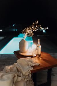 a table with a bottle of wine and a glass at Greece Sea Villas Kaki Thalassa 400m to the beach ,Heated pool ,Athens in Keratea +48 photos