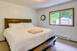 Un dormitorio con una cama grande con ventana. en Seiku Vacation Rental with Deck and Ocean Views, en Sekiu