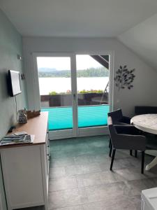 a kitchen with a table and a view of a pool at Haus Kleinbichler in Faak am See