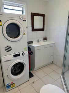 ein Badezimmer mit einer Waschmaschine und einem Waschbecken in der Unterkunft Affordable Inn in Perth