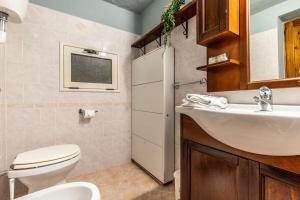 La salle de bains est pourvue de toilettes blanches et d'un lavabo. dans l'établissement San Pantaleo - Coral Apartment 2, à San Pantaleo
