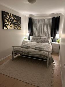 een slaapkamer met een groot bed en een raam bij Affordable Inn in Perth