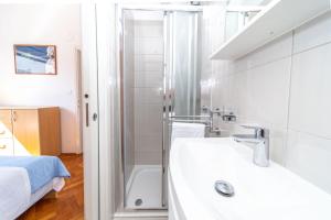 a bathroom with a sink and a shower at Apartments Pende 3122 in Banjol +29 photos