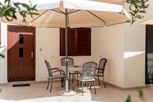 a table and chairs under an umbrella on a patio at Apartments Pende 3122 in Banjol