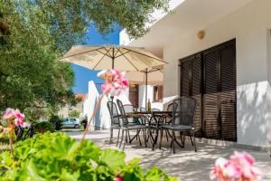 a patio with a table and chairs and an umbrella at Apartments Pende 3122 in Banjol