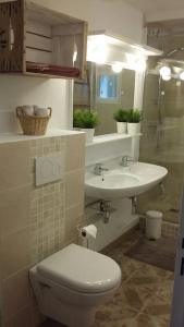 a bathroom with a toilet and a sink at Le Temps Des Cerises. in Vinsobres