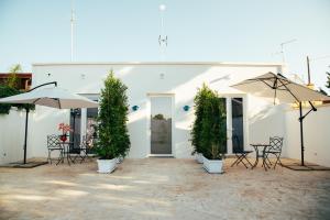 a white building with umbrellas and a table and chairs at Granelli di sabbia in Porto Cesareo