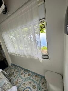 a bedroom with a window and a bed and a floor at L'Incanto in Furore