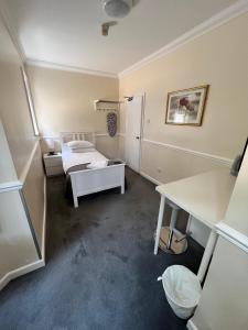 a small room with a bed and a desk at The Admirals Inn Guest House in Bracknell