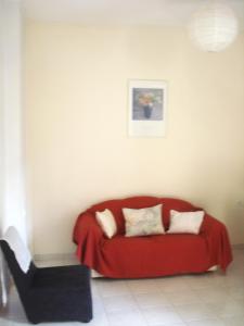 a red couch in a living room with a chair at SOFIES CHOICE Suite in Chalkida