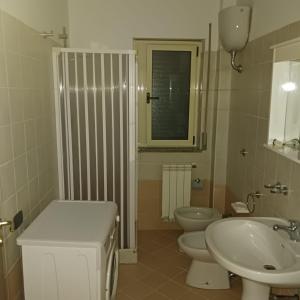 ein weißes Badezimmer mit 2 WCs und einem Waschbecken in der Unterkunft San Silvestro House in Cariati