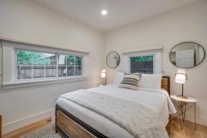 a bedroom with a large bed and two mirrors at Old Town Carriage House with Private Patio in Fort Collins