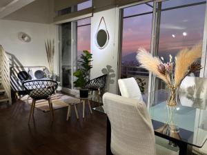 uma sala de jantar com uma mesa de vidro e cadeiras brancas em Suite on the top em Santiago