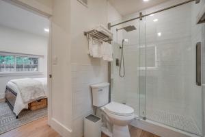 a white bathroom with a toilet and a shower at Old Town Carriage House with Private Patio in Fort Collins