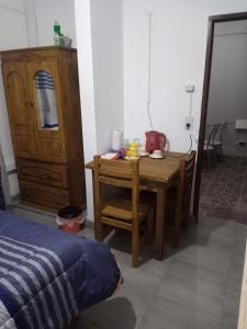 Schlafzimmer mit einem Schreibtisch und einem Tisch mit Stühlen in der Unterkunft Hostal Tia Dora in San Salvador de Jujuy