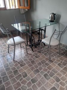 una mesa con 2 sillas y una mesa y sillas de cristal en Hostal Tia Dora en San Salvador de Jujuy